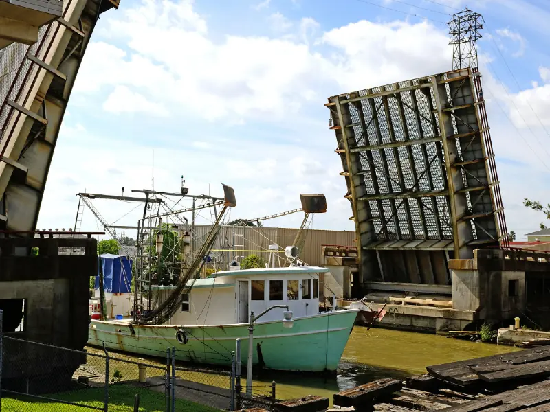 Shrimp boat passing through the raised Harvey Canal drawbridge in Harvey, LA