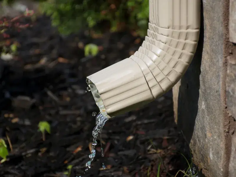 Newly installed downspout directing water away from a New Orleans home's foundation